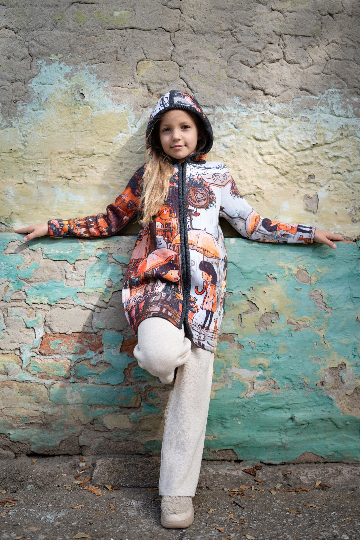 BAIKA kaputić za devojčice Tokio – štrikani kaput sa urbanim motivom kišnog grada, kišobranima i satom u narandžasto-sivim tonovima